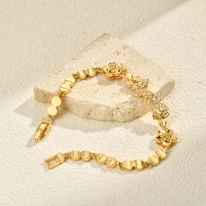 Detailed shot of 24K gold plated bracelet with zirconia butterfly and flower charms
