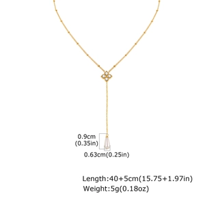 Détail du collier en Y doré avec pendentif trèfle en zircon et perle goutte blanche