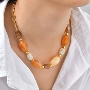 Detailed close-up of resin marble beads and gold metallic spheres on a layering necklace