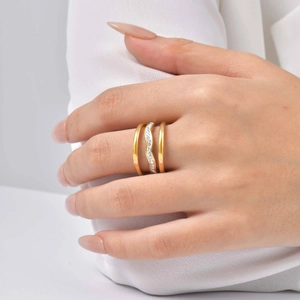 Détail d'une bague triple dorée avec zircons ondulés étincelants et finition polie chic