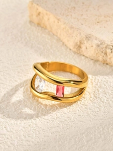 Detailed close-up of wavy gold ring with oval white and pink rectangle gemstones