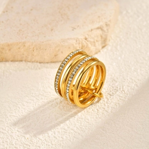 Detail of gold multi-layer ring featuring pave set rhinestones on polished bands