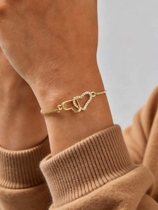 Detail of adjustable 18K gold bracelet with interlocking hearts and white cubic zirconia