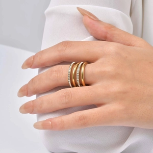 Detail of four-layer gold stacked ring with sparkling crystal rhinestones on a finger