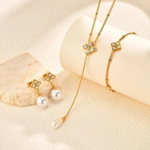 Détails de la parure trèfle comprenant collier doré avec perles blanches et cristaux