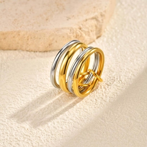 Detailed view of interconnected gold and silver thin bands on a textured stone surface