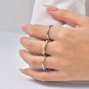 Détail de bagues à trois niveaux avec anneaux en argent poli et design vague pavé doré