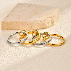 Detailed view of four interlocking gold and silver polished metal rings on a stone surface