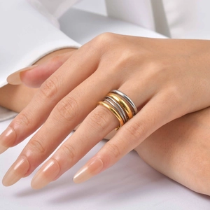 Detail of stacked gold and silver minimalist rings worn for a stylish layered look