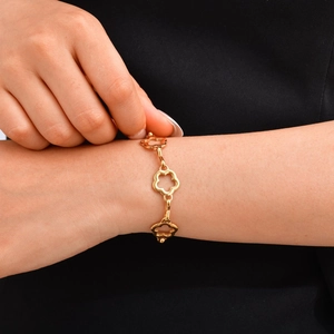 Vista dettagliata di un bracciale placcato oro 18K con fiori traforati sul polso