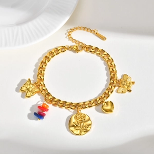 Détail de bracelet à chaîne dorée avec breloques papillon, pièce rose et abeille