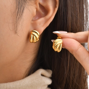 Elegant gold-tone stainless steel drop earrings with wavy layered texture on a female model
