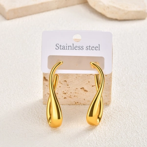 Detail of twisted gold teardrop earrings in polished stainless steel on display stand