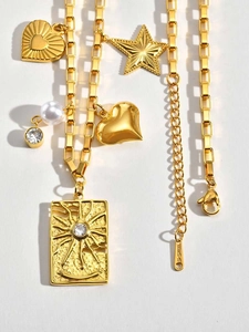 Détail macro de pendentifs en acier doré avec perles et relief à rayons de soleil