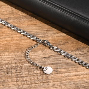 Detail of silver Cuban link chain showing lobster clasp and adjustable extension chain