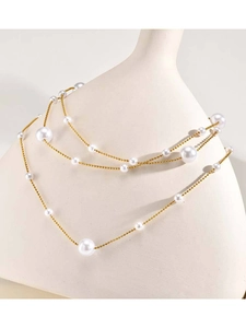 Dettaglio della collana a doppio strato in acciaio dorato con perle e pendente in zircone