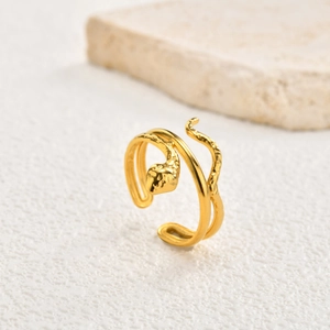 Detail of golden triple snake-shaped ring with textured scales and adjustable open design