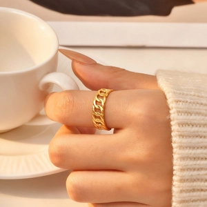Detailed close-up of a golden triple-layered snake weave ring worn with a knit sweater