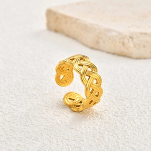 Detailed close-up of triple-layered woven golden stainless steel ring on a stone base