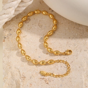 Close-up of 18K gold football bead anklet with lobster clasp and extension chain