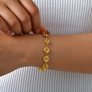 Elegant gold stainless steel spiral link bracelet for women styled on a model wrist