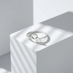 Detail showing interlocking open heart design on minimalist stainless steel ring band