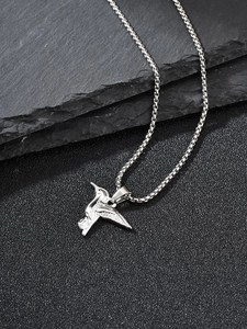 Macro shot of silver hummingbird pendant with detailed wing textures and box chain link