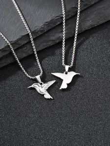 Detail of silver hummingbird pendants in realistic and minimalist styles on black stone