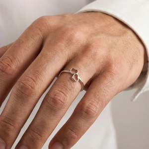 Macro view of interlocking heart design on a polished silver stainless steel ring