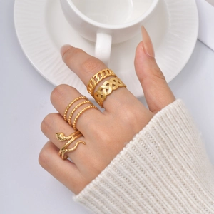 Four-piece gold stainless steel ring set with snake and braided designs on model's hand