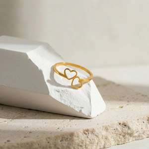 Detailed view of gold minimalist ring with double interlocking hollow heart design