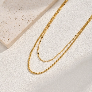 Double-layered 18K gold plated stainless steel beaded chain necklace on stone background