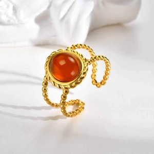 Detail of bohemian gold layered ring with amber gemstone and beaded texture finish