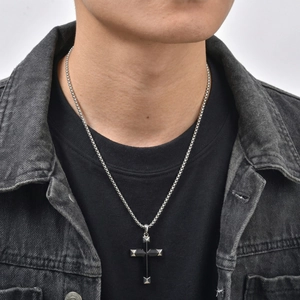 Detail shot of a men's punk cross necklace with black onyx and silver stud edges