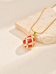 Macro shot of red and white enamel Easter egg pendant necklace with crystal accents