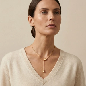 Collier minimaliste en Y doré avec pendentif goutte d'eau et chaîne serpent sur un mannequin