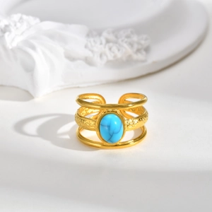 Detailed macro view of triple-layered golden ring featuring a turquoise stone inlay