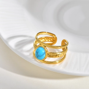 Detail of bohemian gold triple-layer open ring featuring a turquoise stone inlay