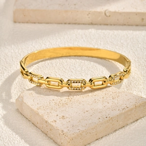 Close-up of gold chain bangle featuring pavé zircon rectangular links on stone base