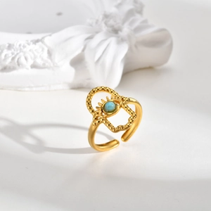 Macro shot of gold bohemian ring with turquoise evil eye detail on white stone