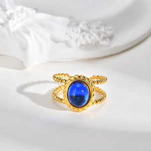 Detail of vintage double-layer beaded gold ring with deep blue oval gemstone