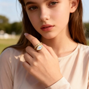 Golden Evil Eye open ring with micro-pave zircons worn by a model in outdoor light