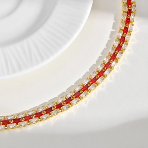 Detail macro view of golden double-row bracelet with red and white baguette-cut stones