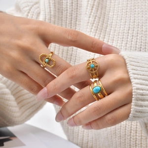 Three-layer bohemian gold ring set featuring turquoise stones worn on hand