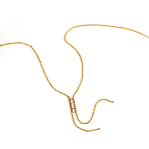 Dettaglio della collana a Y dorata con catena a sfere e quattro zirconi bianchi