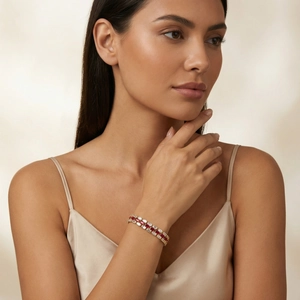Close-up of elegant gold watch-band bracelet with red and white rectangular zircons