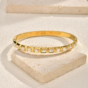 Detailed view of a gold-plated stainless steel hinge bracelet with rectangular zircons