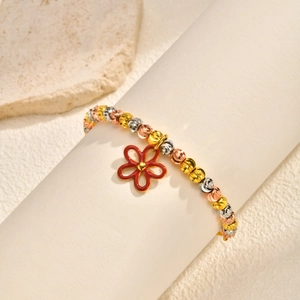Detail of adjustable box chain bracelet with tricolor beads and red enamel flower charm