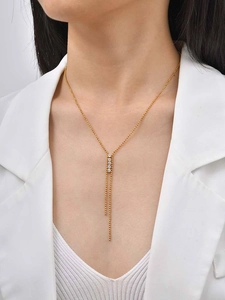 Dettaglio della collana a Y dorata con ciondolo in zircone e doppia nappa sul collo