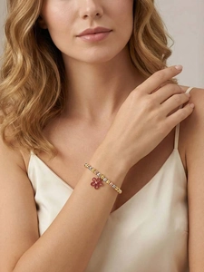 Close-up of adjustable bead bracelet featuring three-tone metal beads and a pink flower charm